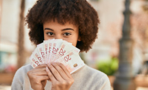 נערה מחייכת ומחזיקה שטרות (אילוסטרציה: Krakenimages.com, shutterstock)